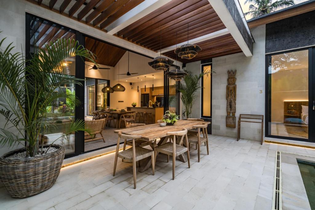 a patio with a wooden table and chairs at Villa Welcome by BaliSuperHost in Ubud