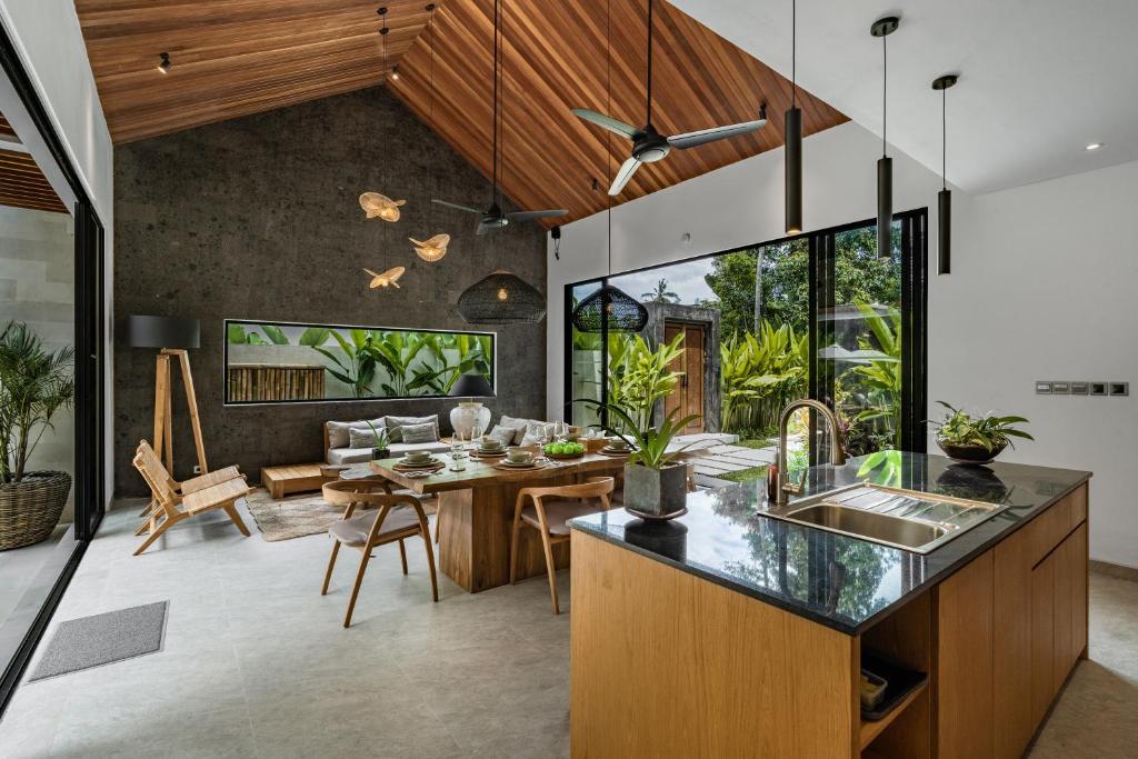 an open kitchen and dining room with a table and chairs at Villa Welcome by BaliSuperHost in Ubud