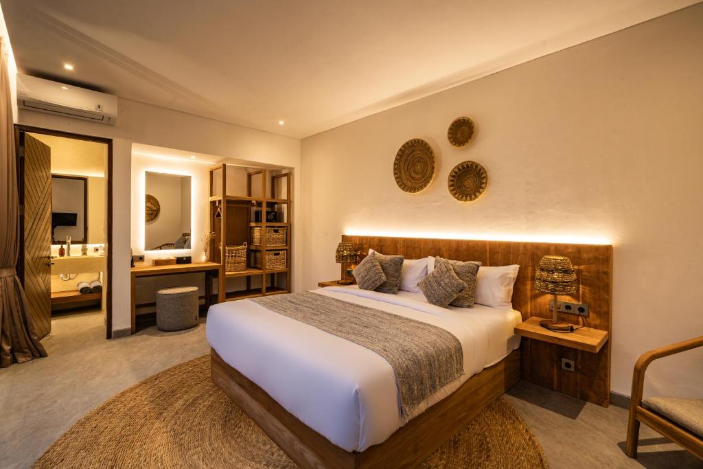 a bedroom with a large bed and a bathroom at Villa Welcome by BaliSuperHost in Ubud