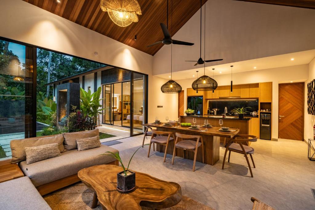 an open living room with a couch and a table at Villa Welcome by BaliSuperHost in Ubud