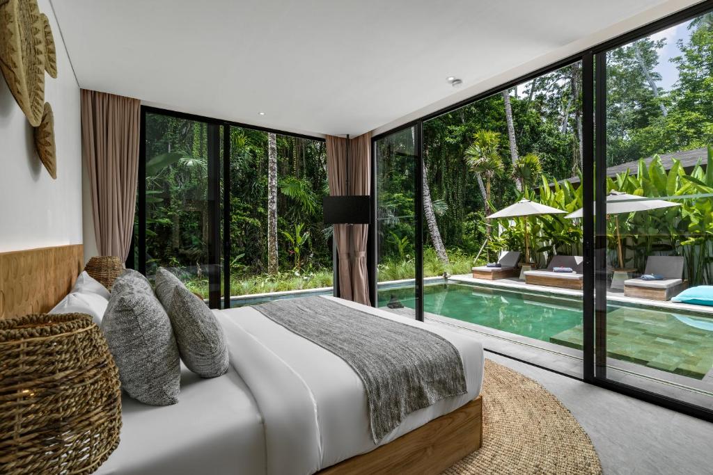 a bedroom with a bed and a pool at Villa Welcome by BaliSuperHost in Ubud