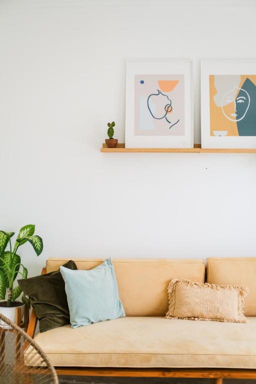 a couch with pillows on a white wall at Villa Naia Berawa in Canggu