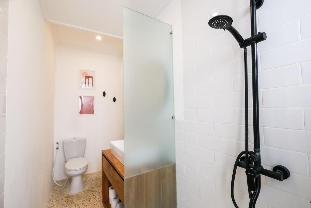 a bathroom with a shower and a toilet at Villa Naia Berawa in Canggu