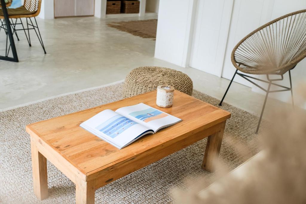 a coffee table with a book and a candle on it at Villa Naia Berawa in Canggu