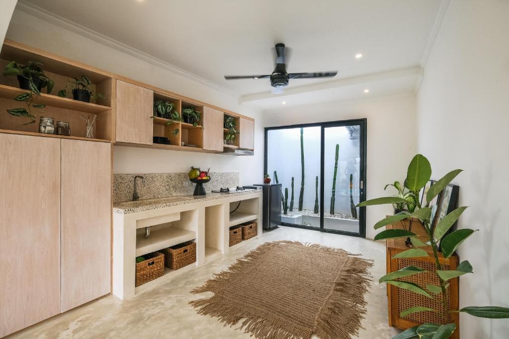 a living room with a fireplace and a plant at Villa Naia Berawa in Canggu