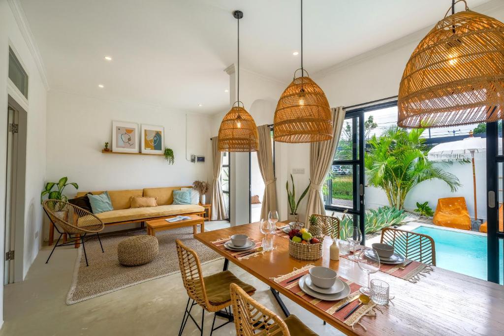 a living room with a table and a couch at Villa Naia Berawa in Canggu