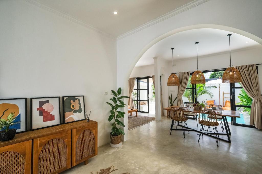 an open living room with a table and chairs at Villa Naia Berawa in Canggu