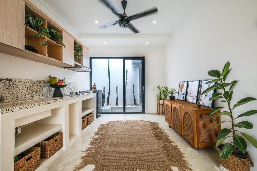 a living room with a fireplace and a ceiling fan at Villa Naia Berawa in Canggu