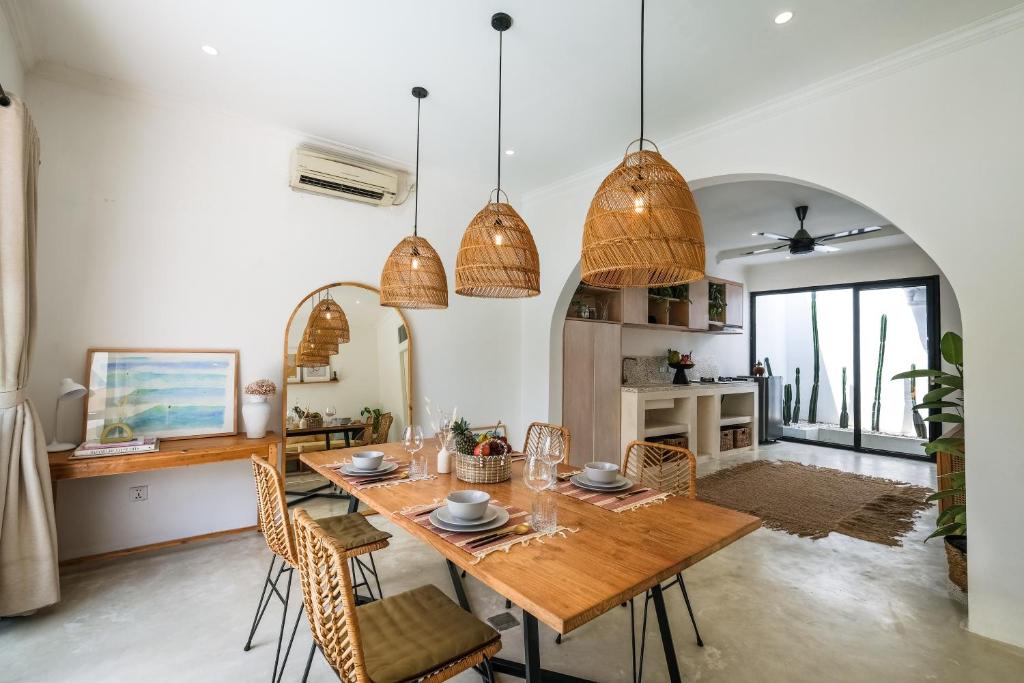 a dining room with a wooden table and chairs at Villa Naia Berawa in Canggu