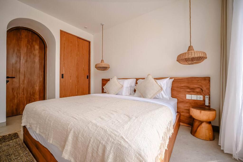 Tempat tidur dalam kamar di Maison Coucou - Modern Minimalist 3BR Villa near Tanah Lot