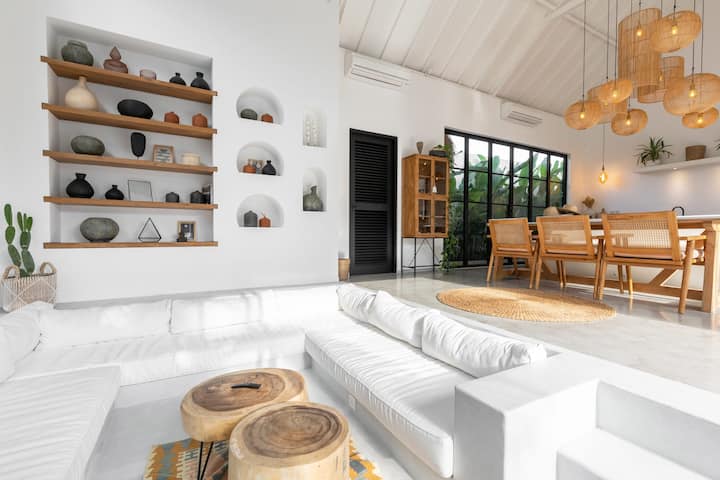 Modern tropical home decorating package featuring rattan furniture, teak wood accents, boho textiles, outdoor loungers, and artisanal décor for stylish villas.