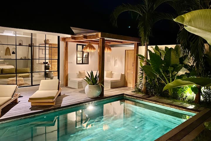 The Young Villas kolam renang baru dan bersih di malam hari menghadap ke kamar tidur utama mewah berjenjang.